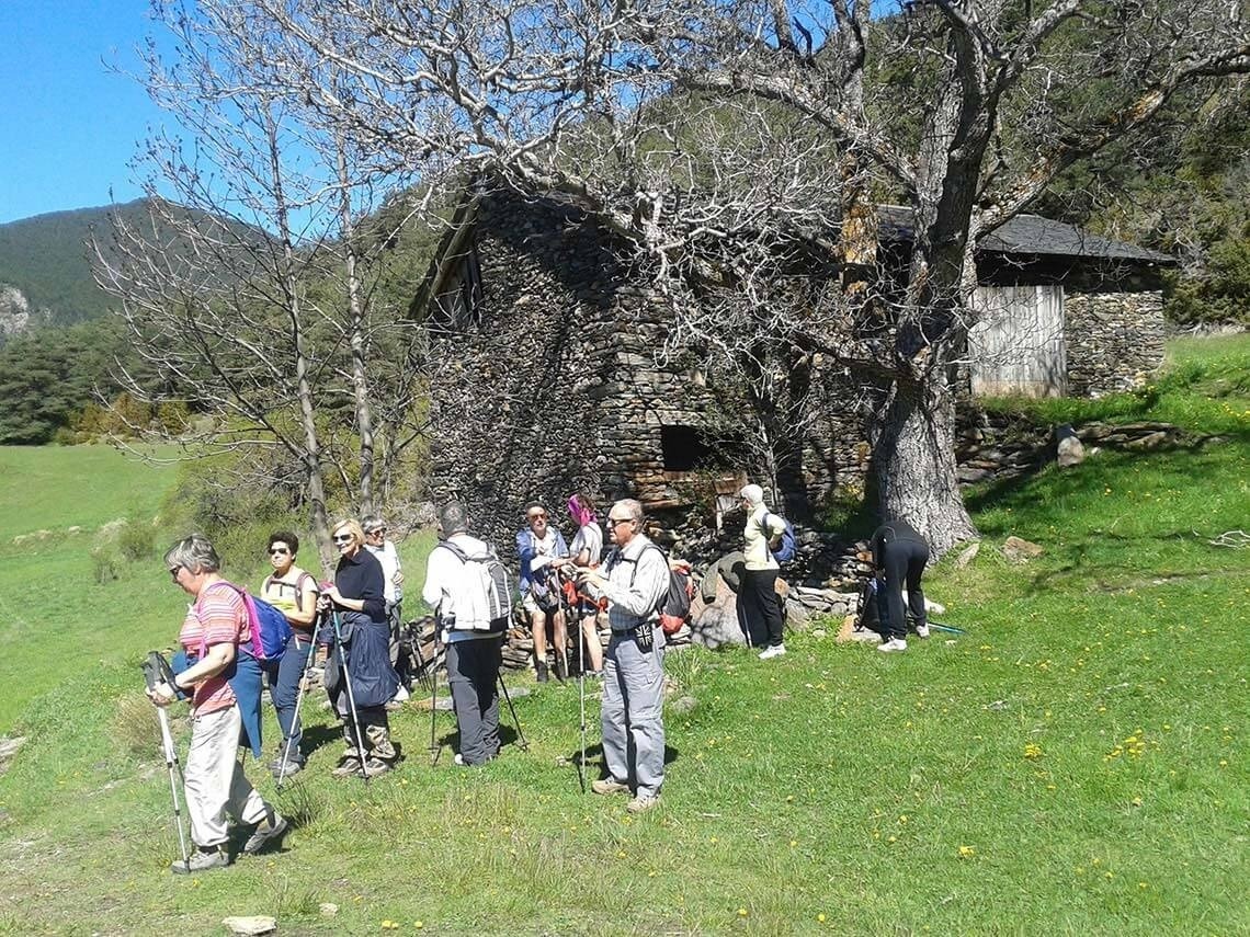un grupo de excursionistas se paran frente a un edificio de piedra
