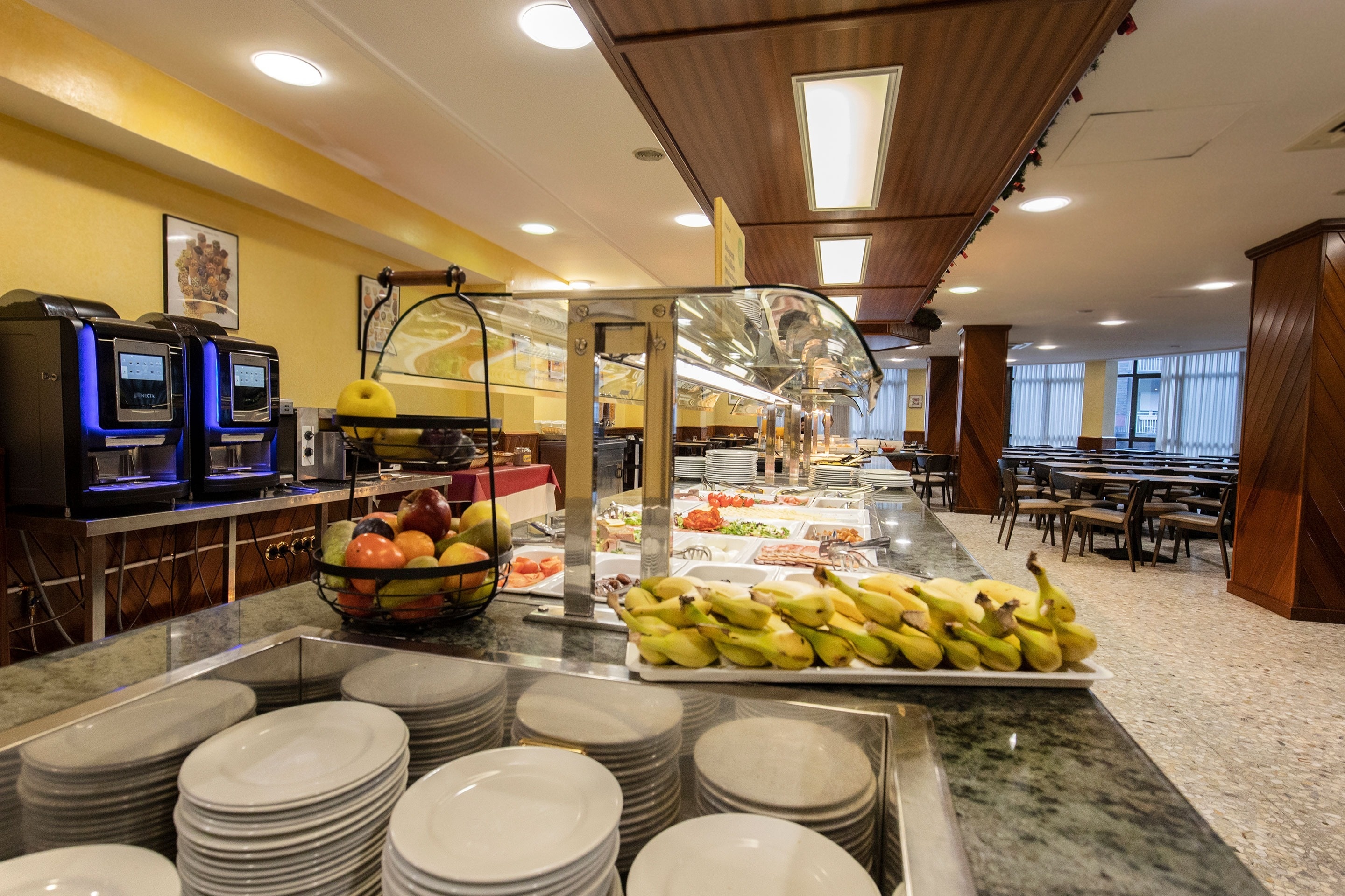 une salle à manger avec un plateau de bananes et un panier de fruits