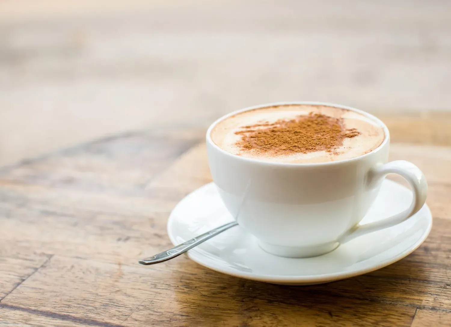 NEXTA: Corporativa – Cappuccino à la cannelle sur table en bois.