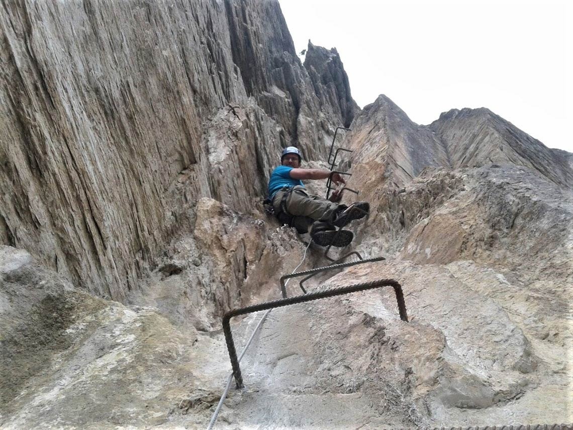 un hombre sube una escalera de metal en una montaña
