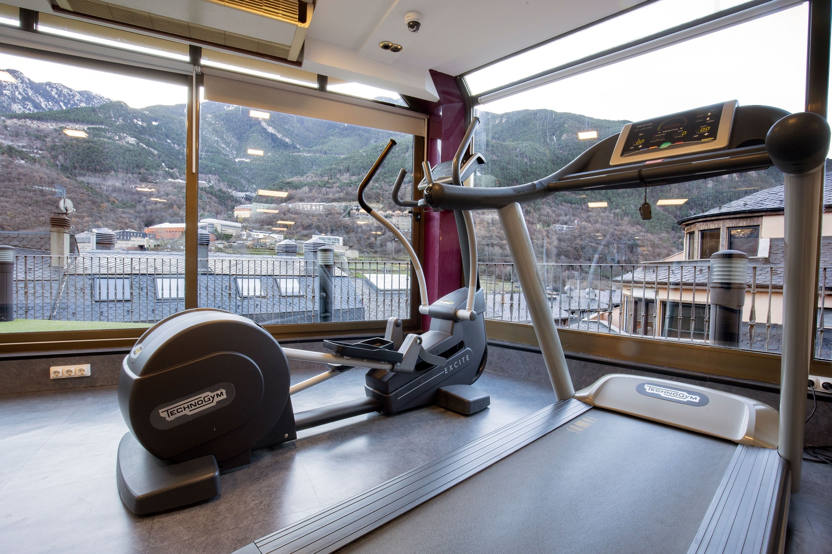 un vélo elliptique et un tapis roulant technogym dans une salle de sport