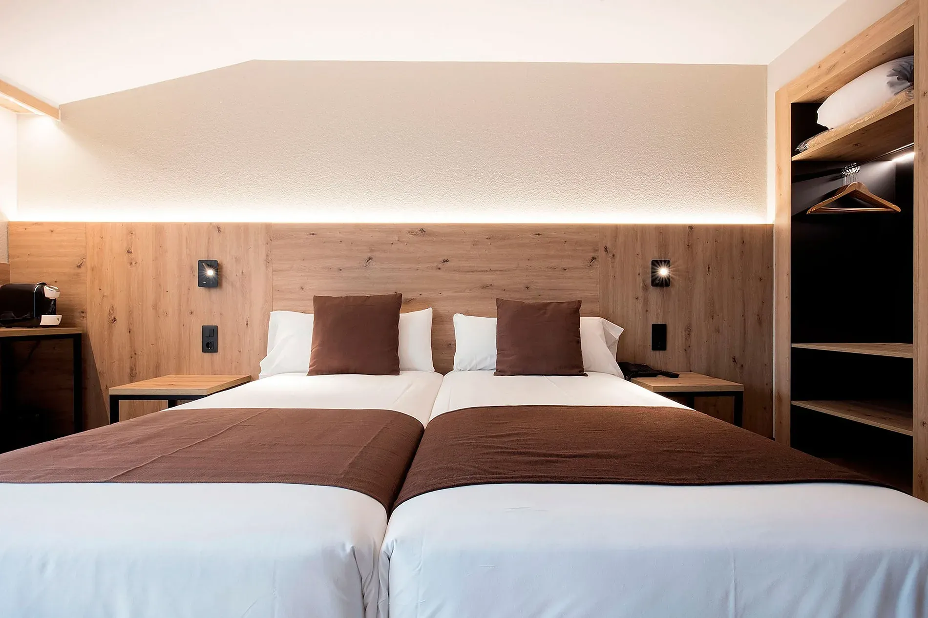 Habitación doble con camas separadas, ropa de cama blanca y mantas marrones en Hotel Comtes d’Urgell.