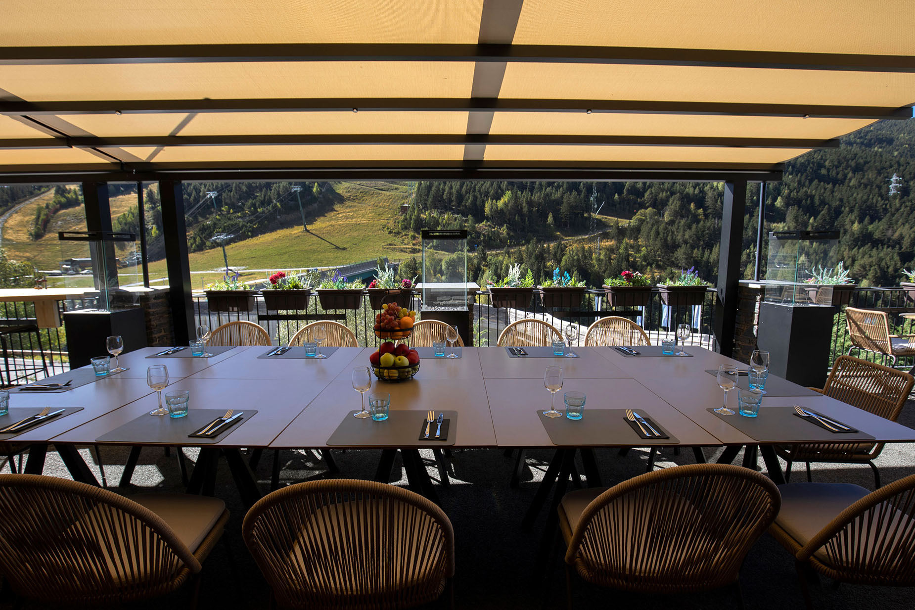 Terraza de hotel con mesas y sillas, vista a montaña y NEXTA: Corporativa.
