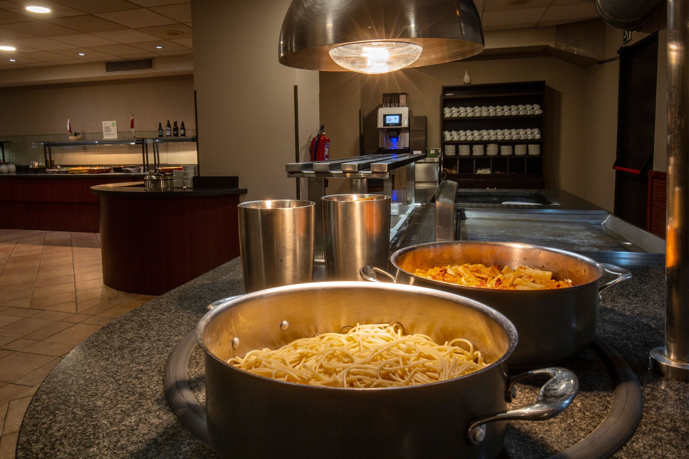 a pot of spaghetti sits on a counter in a restaurant