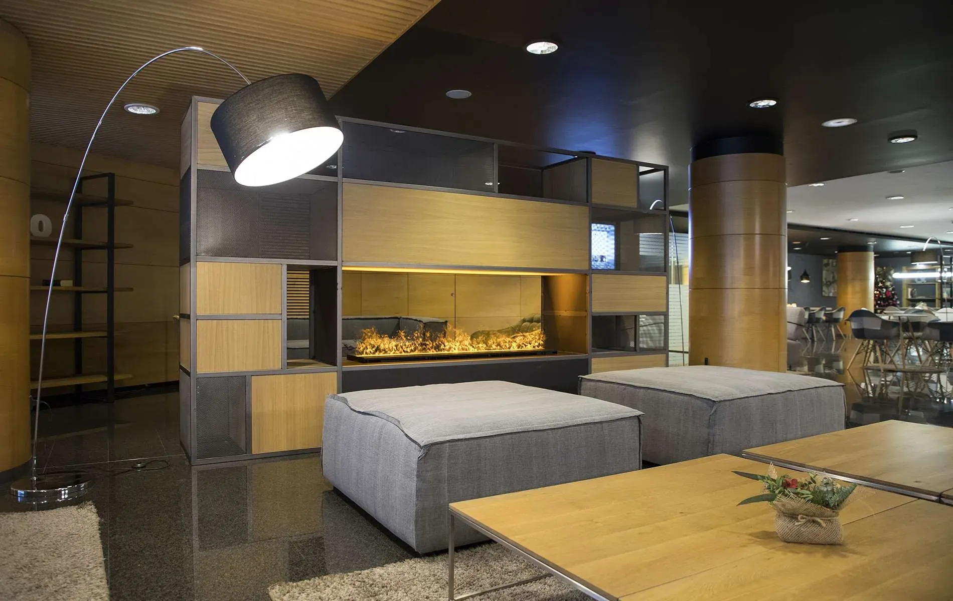 Salon de l'Hôtel Nexta Escaldes avec cheminée design et poufs confortables