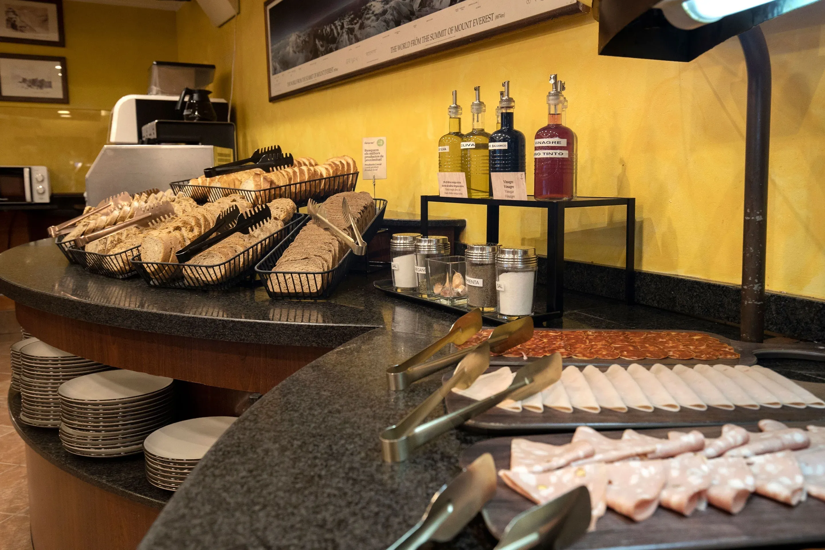 NEXTA: Corporativa hotel breakfast buffet with breads, meats, and condiments.