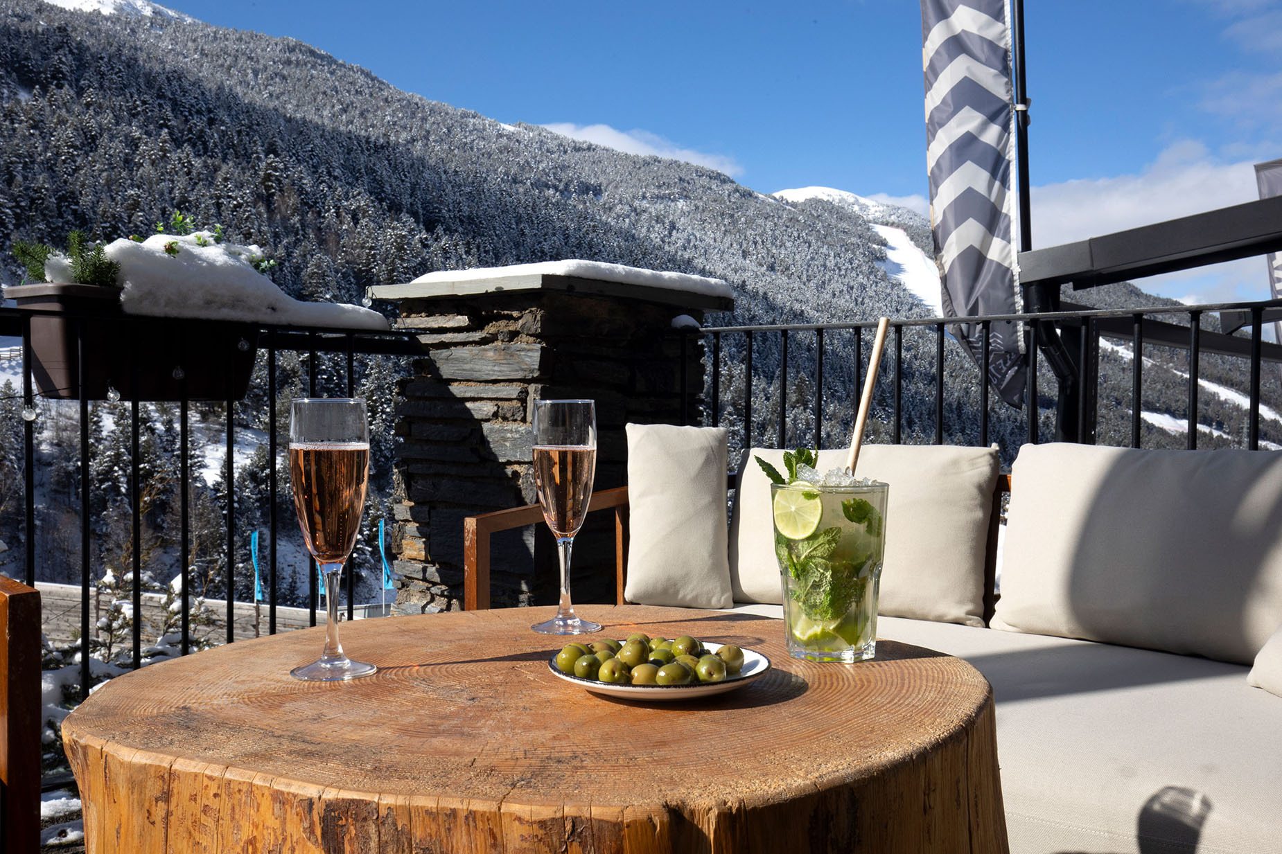 Disfruta de una bebida en la terraza de nuestro hotel con vista a las montañas nevadas. NEXTA: Corporativa