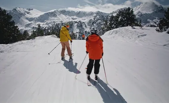 Skiing down snowy slopes with mountain views, ideal for your NEXTA: Corporativa.