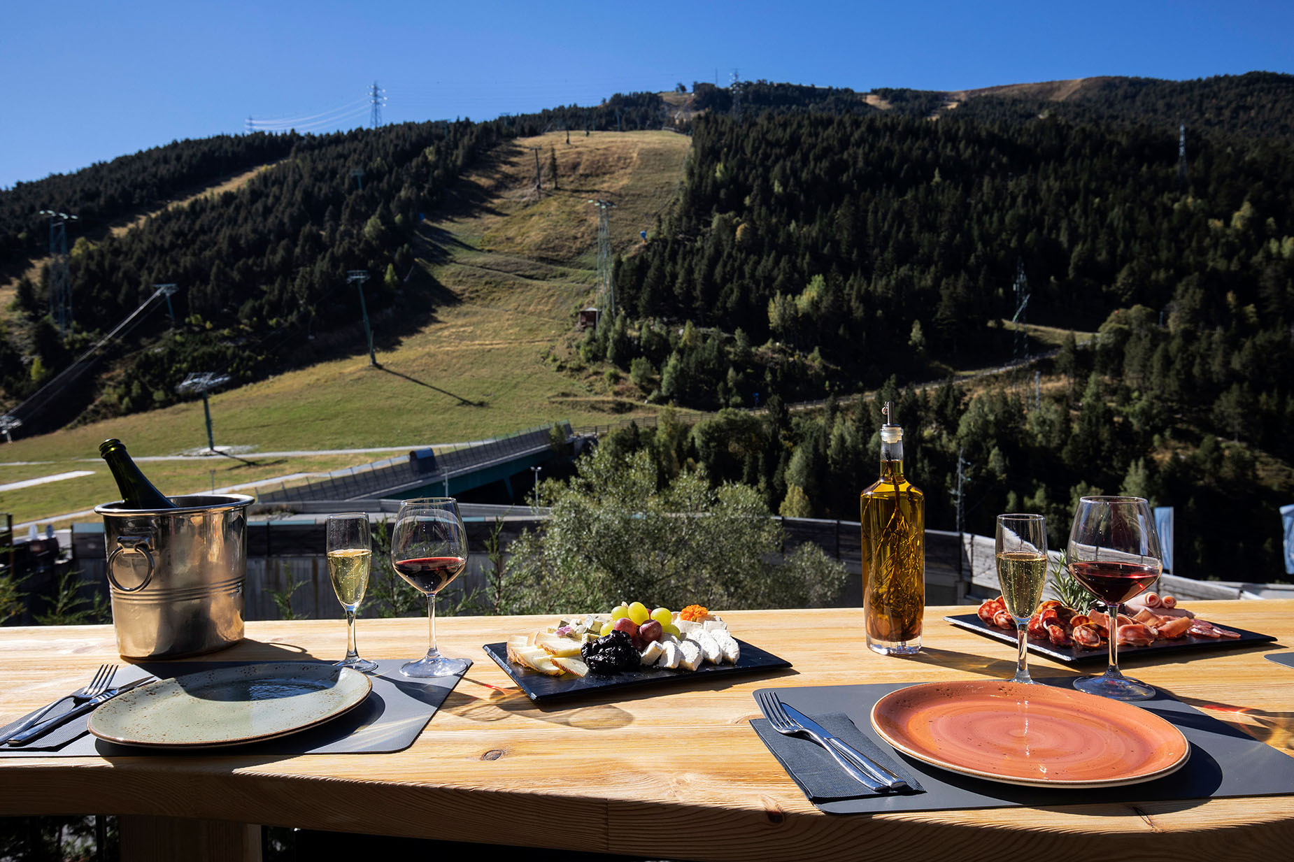 NEXTA: Corporativa: Mesa con vino y tapas con vista a montaña y teleférico, ideal para vacaciones.