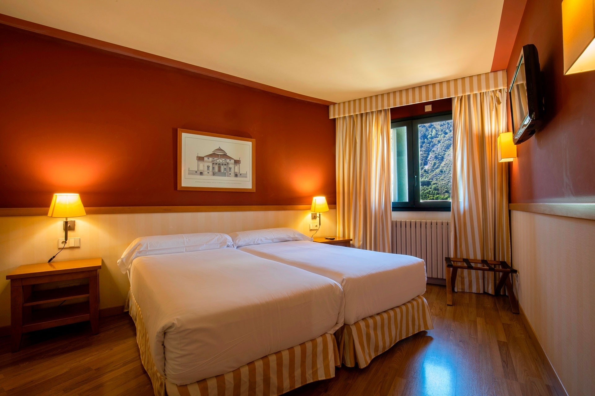 a hotel room with two beds and a picture of a building on the wall