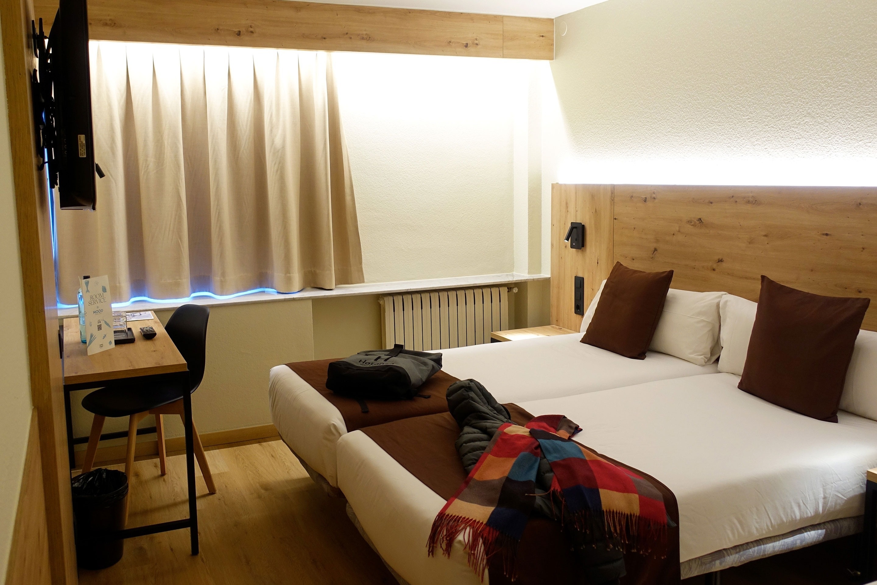 una habitació d' hotel amb dues camas i un radiador