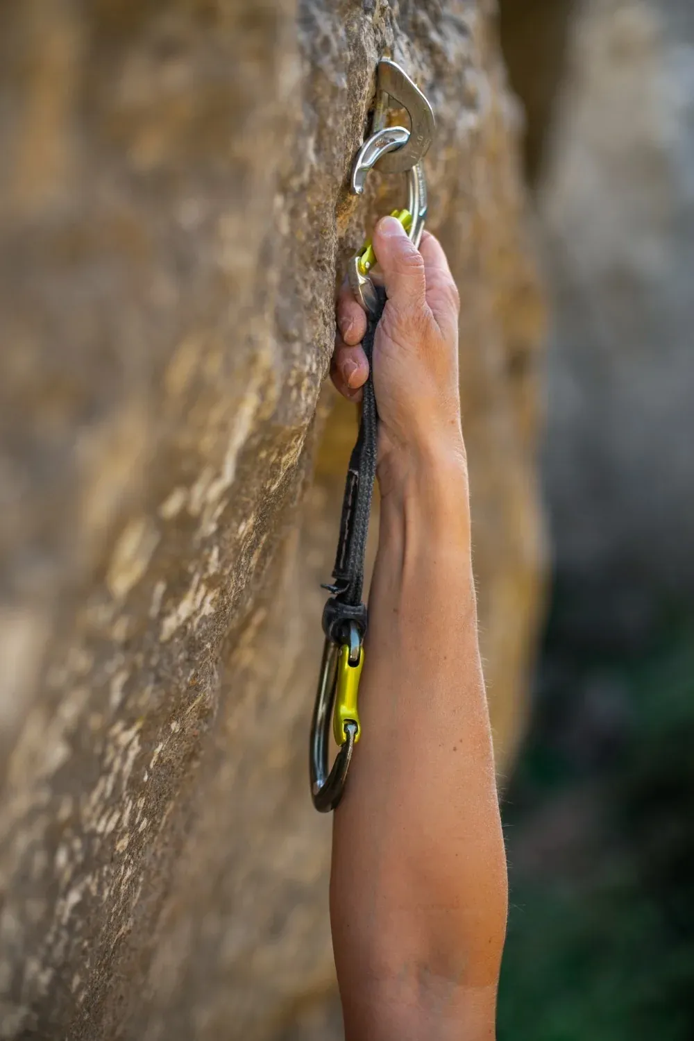 NEXTA: Corporativa - Climber attaching anchor to rock.