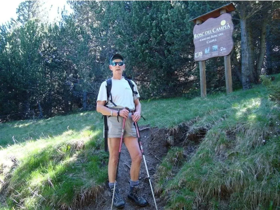 Senderista con bastones cerca de un cartel de bosque. NEXTA: Corporativa.