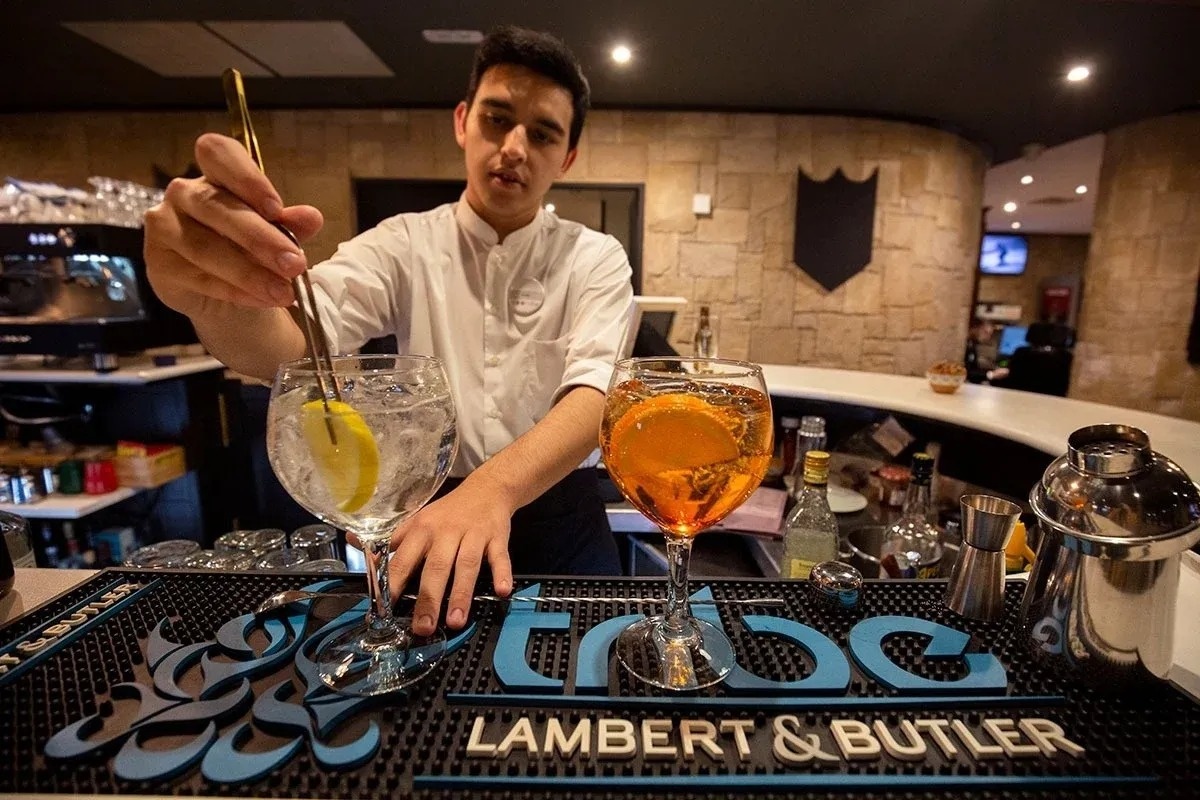 un barman prepara un cóctel en un mostrador de lambert & butler