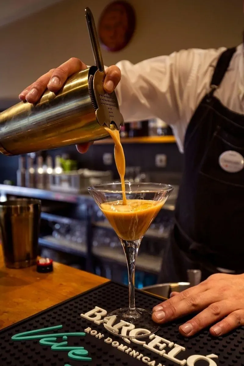 Bartender pouring cocktail from shaker. Perfect for NEXTA corporate events.