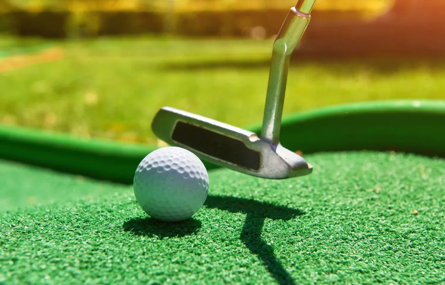 NEXTA: Luxury golf course with putter and ball on artificial turf.
