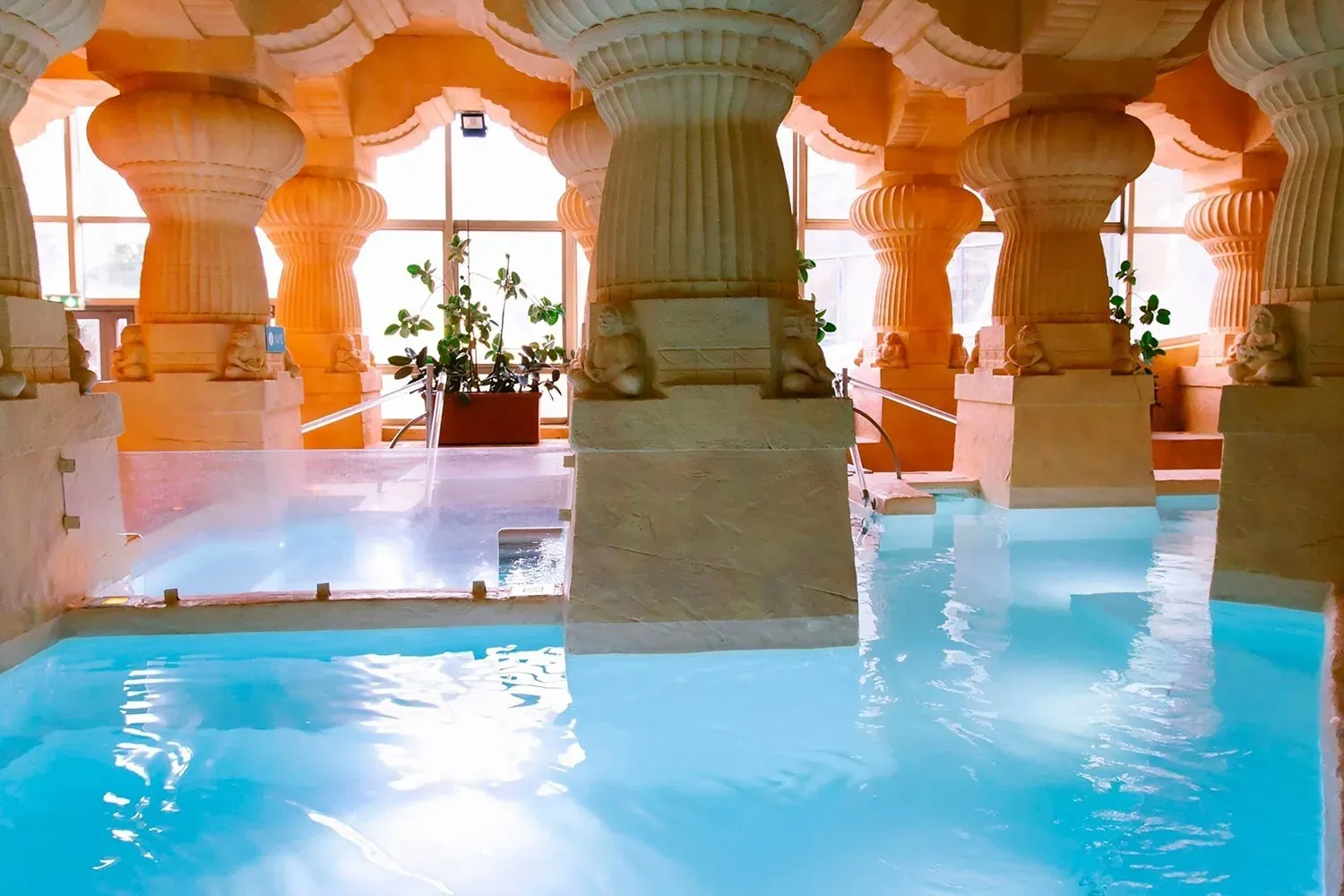 NEXTA: Corporativa pool with ornate columns and waterfalls.