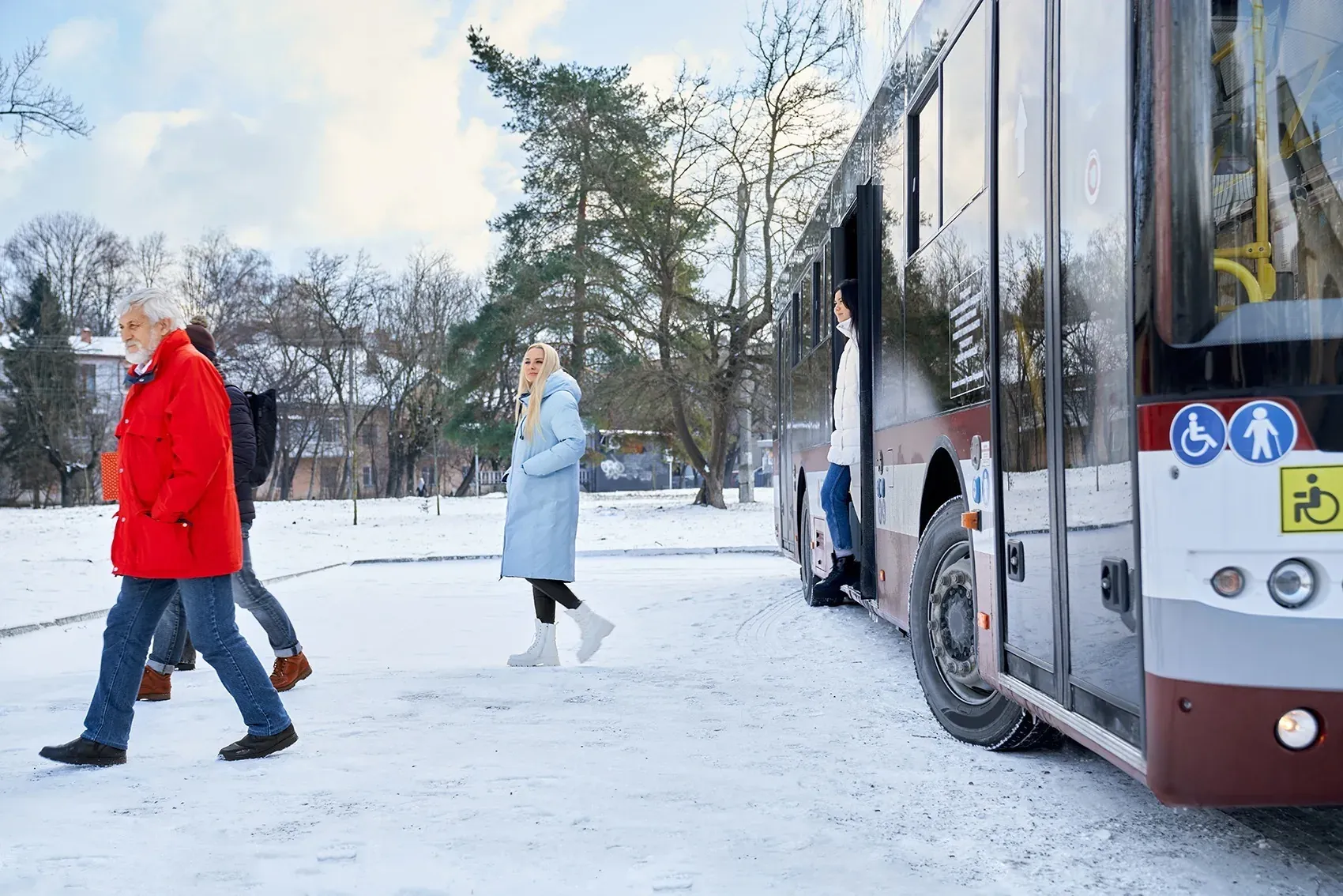 People boarding NEXTA: Corporativa bus in snowy winter.