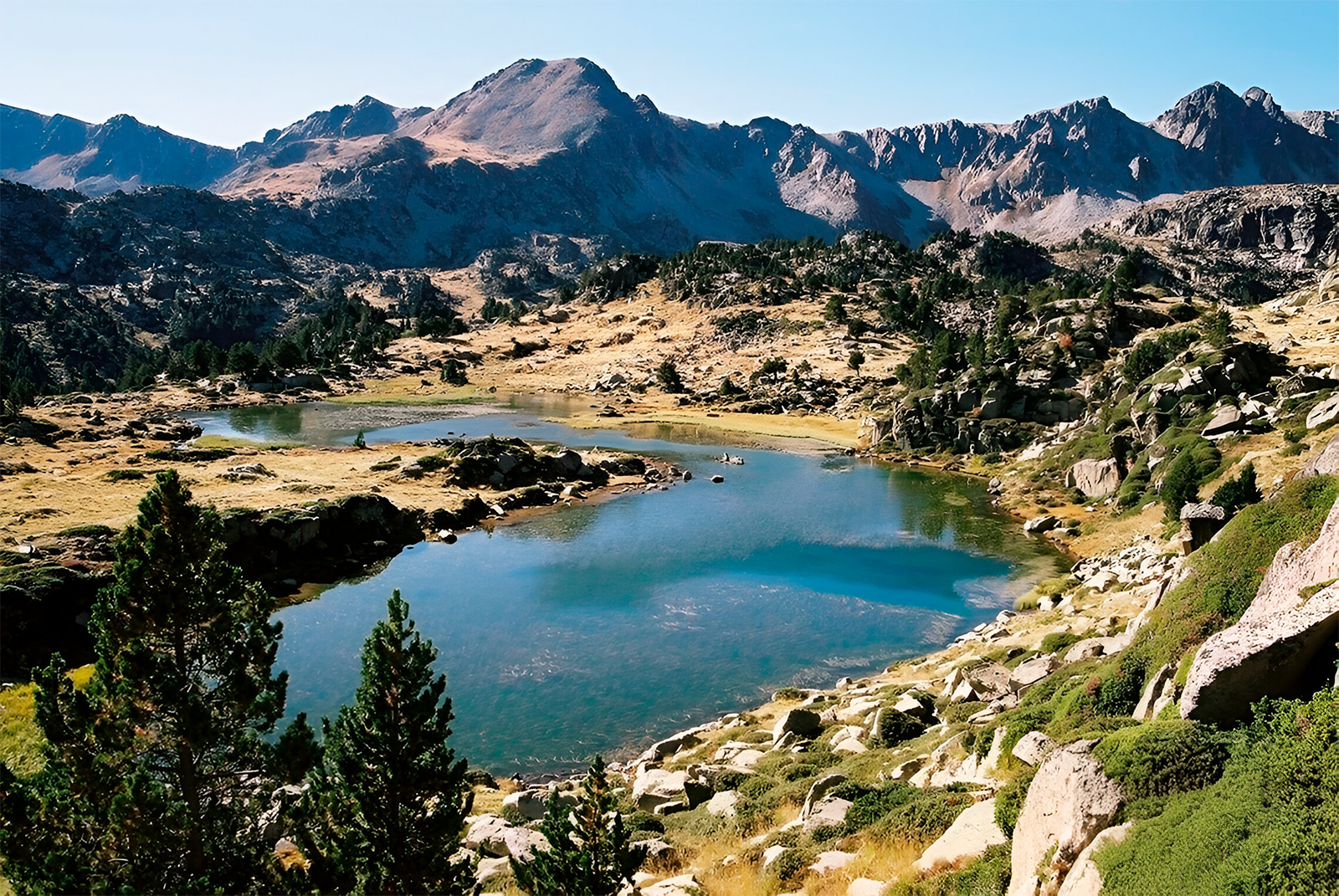 un lago rodeado de montañas y árboles en un valle