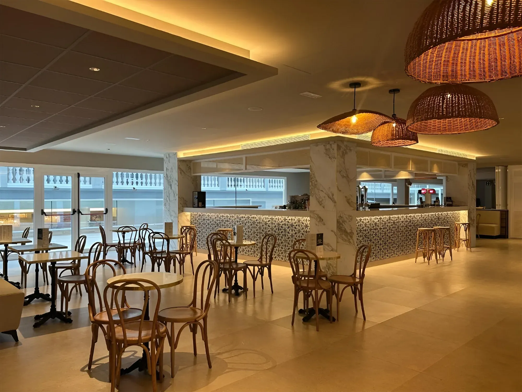 Bar NEXTA: Corporativa avec tables en bois et sièges dans un espace lumineux.