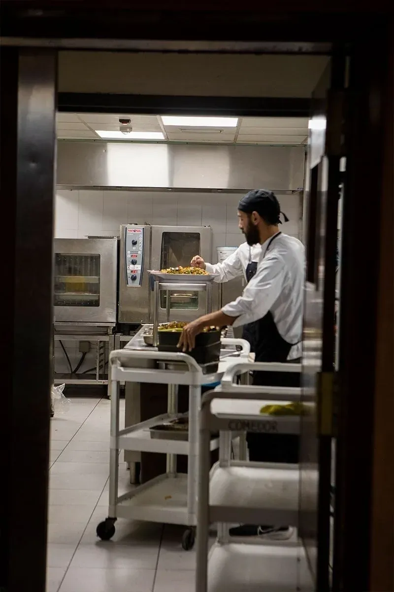 Chef sirviendo comida en la cocina corporativa NEXTA.