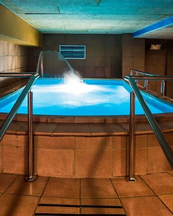 Piscina NEXTA: Corporativa, con cascada y barandillas de acero inoxidable.