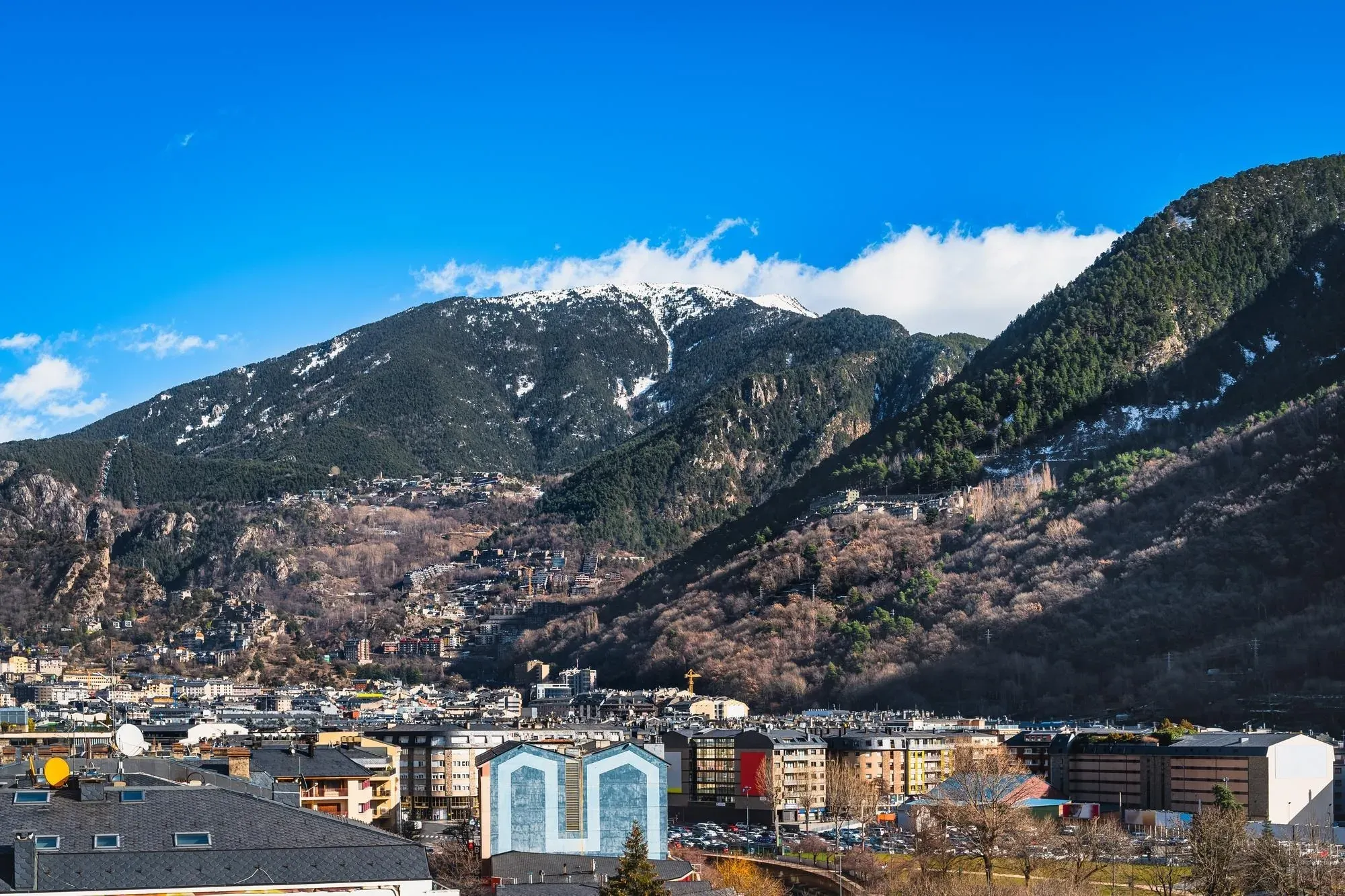 Vista panorámica de NEXTA: Corporativa, rodeada de majestuosas montañas nevadas.