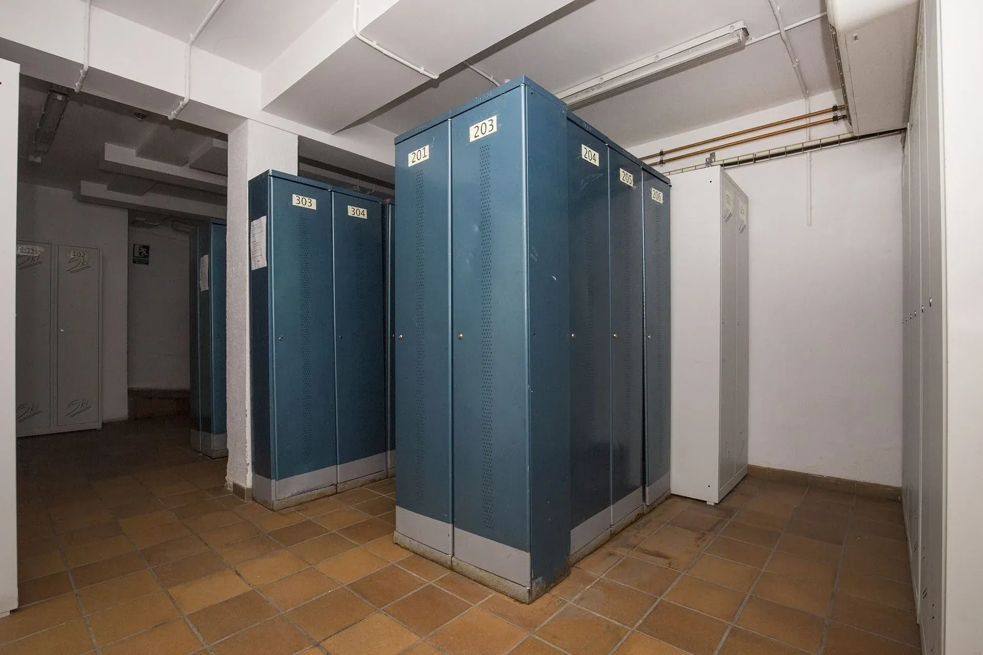 Taquillas NEXTA: Corporativa numeradas, pasillo del hotel con suelo de baldosas.