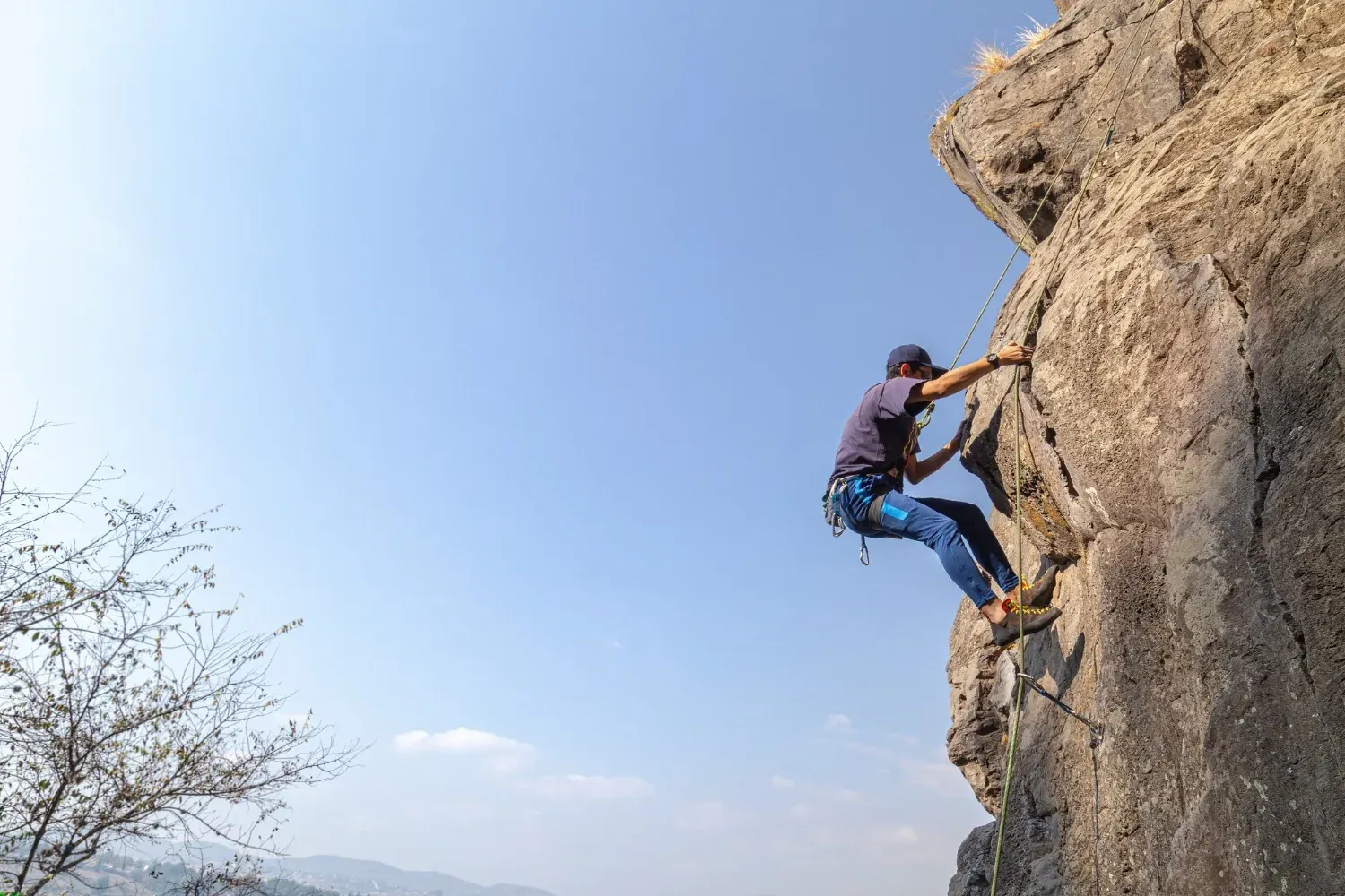 Man rock climbing, perfect for NEXTA: Corporativa retreats with a view.