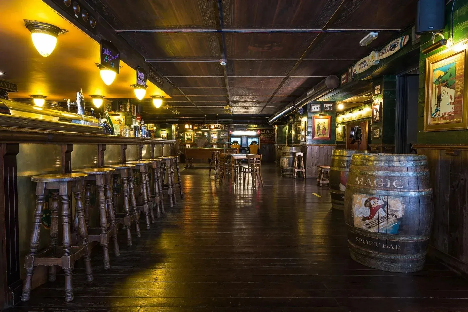 NEXTA: Corporativa Irish pub style bar with wooden barrels and stools.