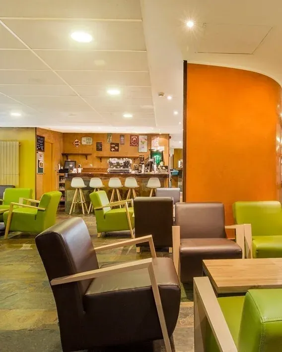 Salón de bar NEXTA: Corporativa con sillones modernos y zona de café acogedora.