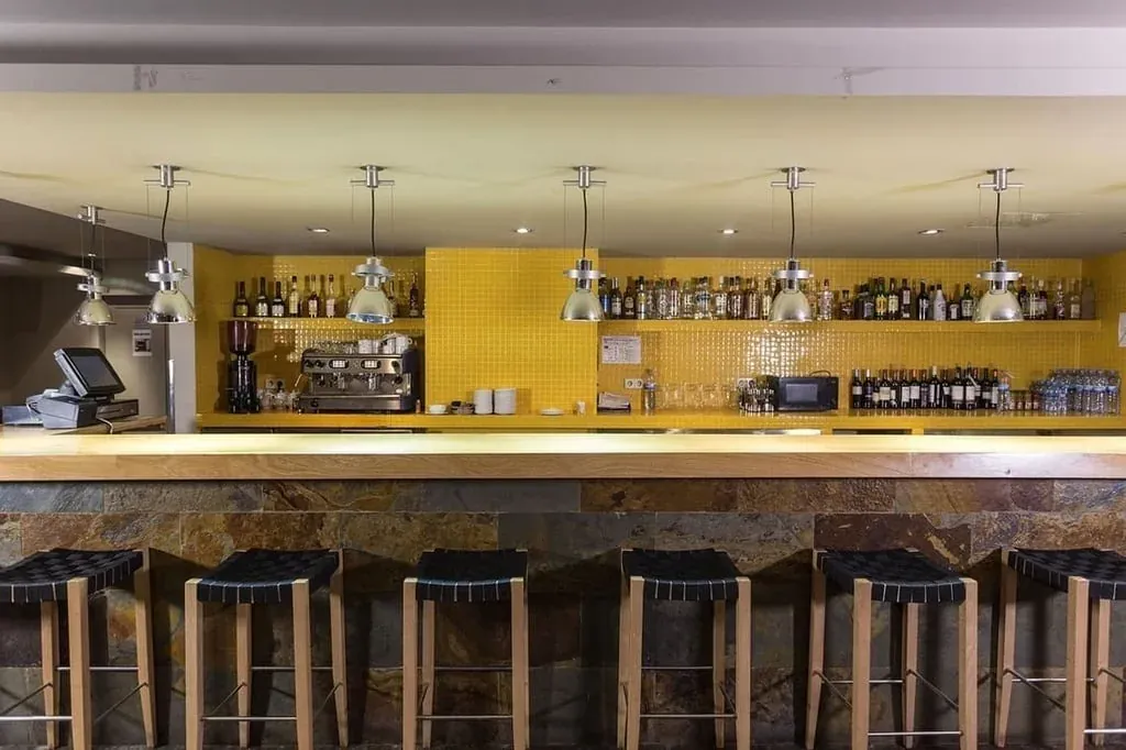 Bar moderno con taburetes y botellas de alcohol. Ideal para NEXTA: Corporativa.