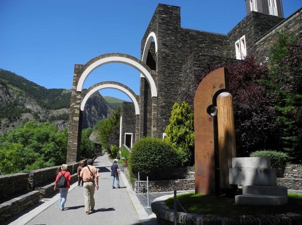 un grupo de personas camina por un camino hacia un edificio de piedra