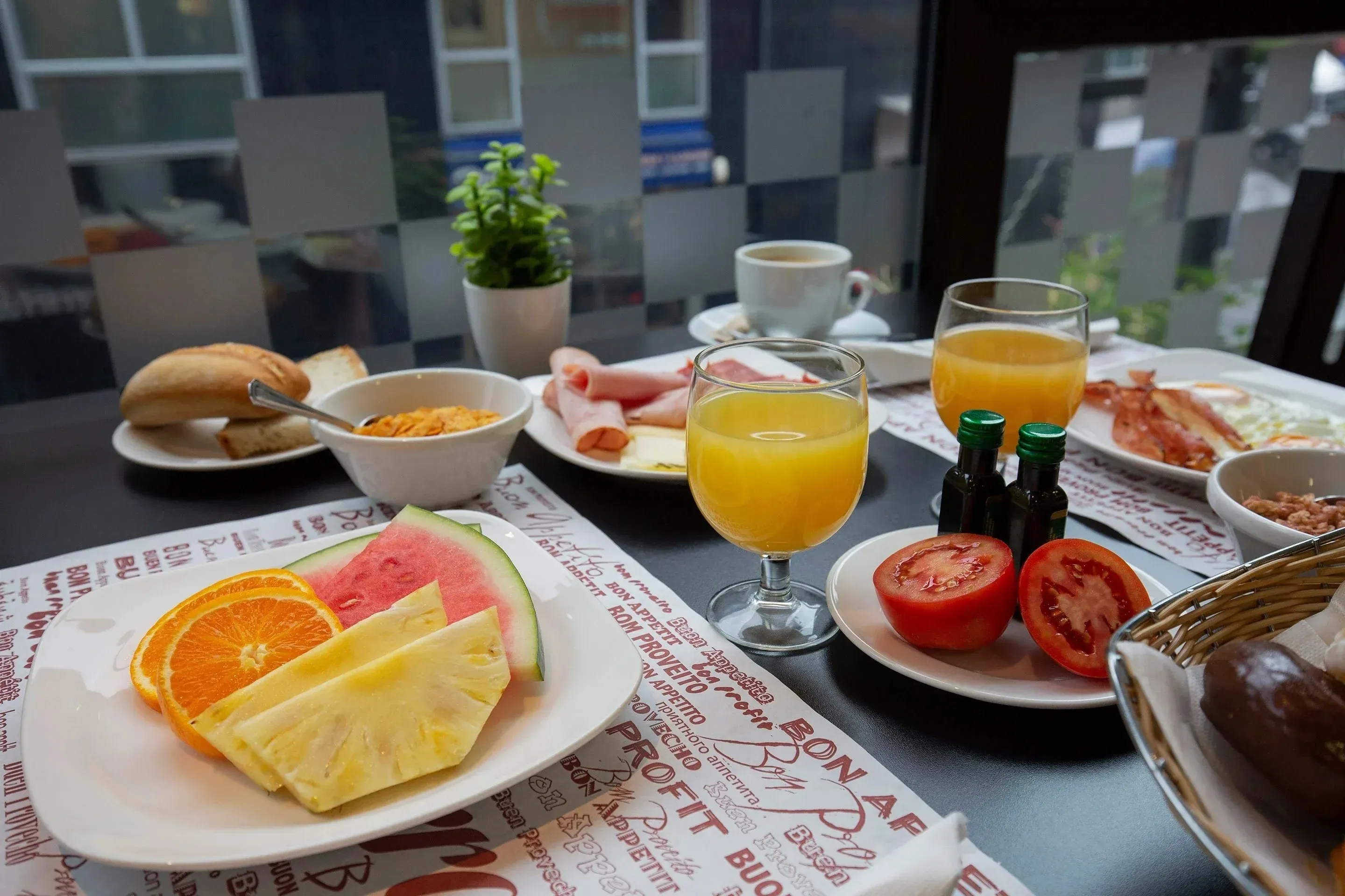 NEXTA Corporate breakfast buffet with fruits, coffee, and bacon.