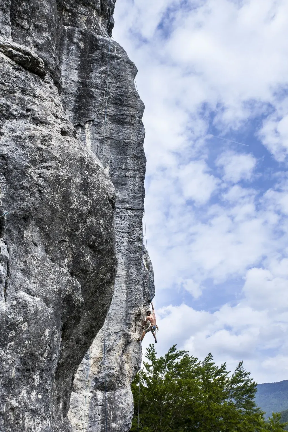 NEXTA: Corporativa; rock climber on cliff face with blue sky.