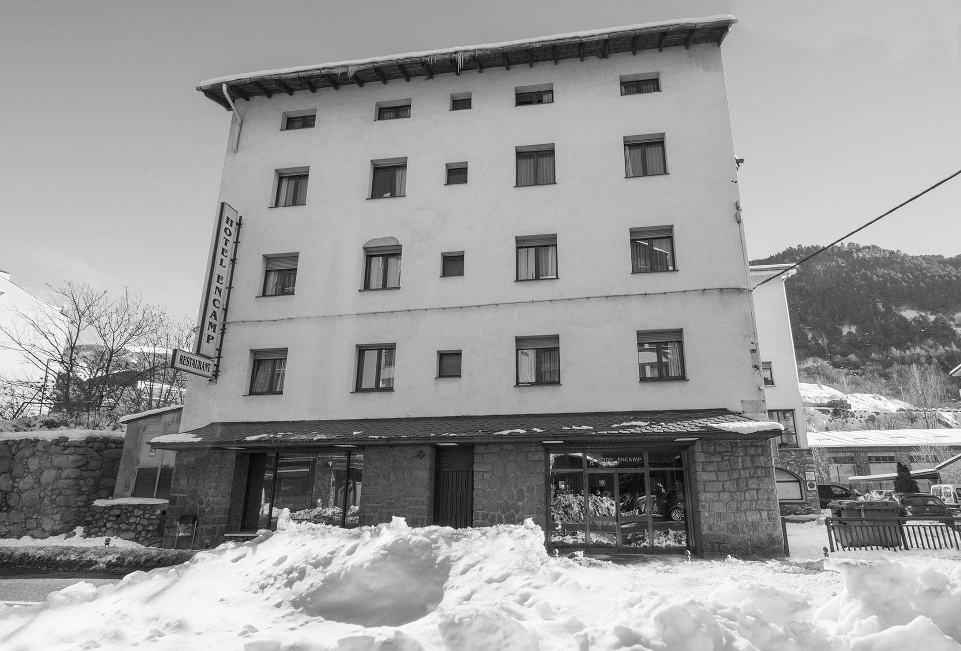 un edificio blanco cubierto de nieve con la palabra hotel en la parte superior=s1900