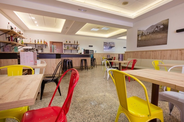 une salle à manger avec des chaises rouges et jaunes