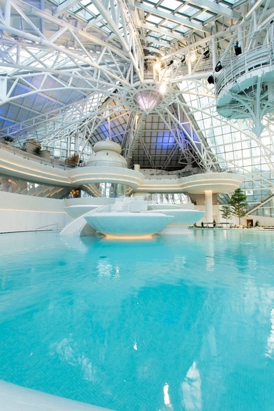 una gran piscina dentro de un edificio con un techo de vidrio