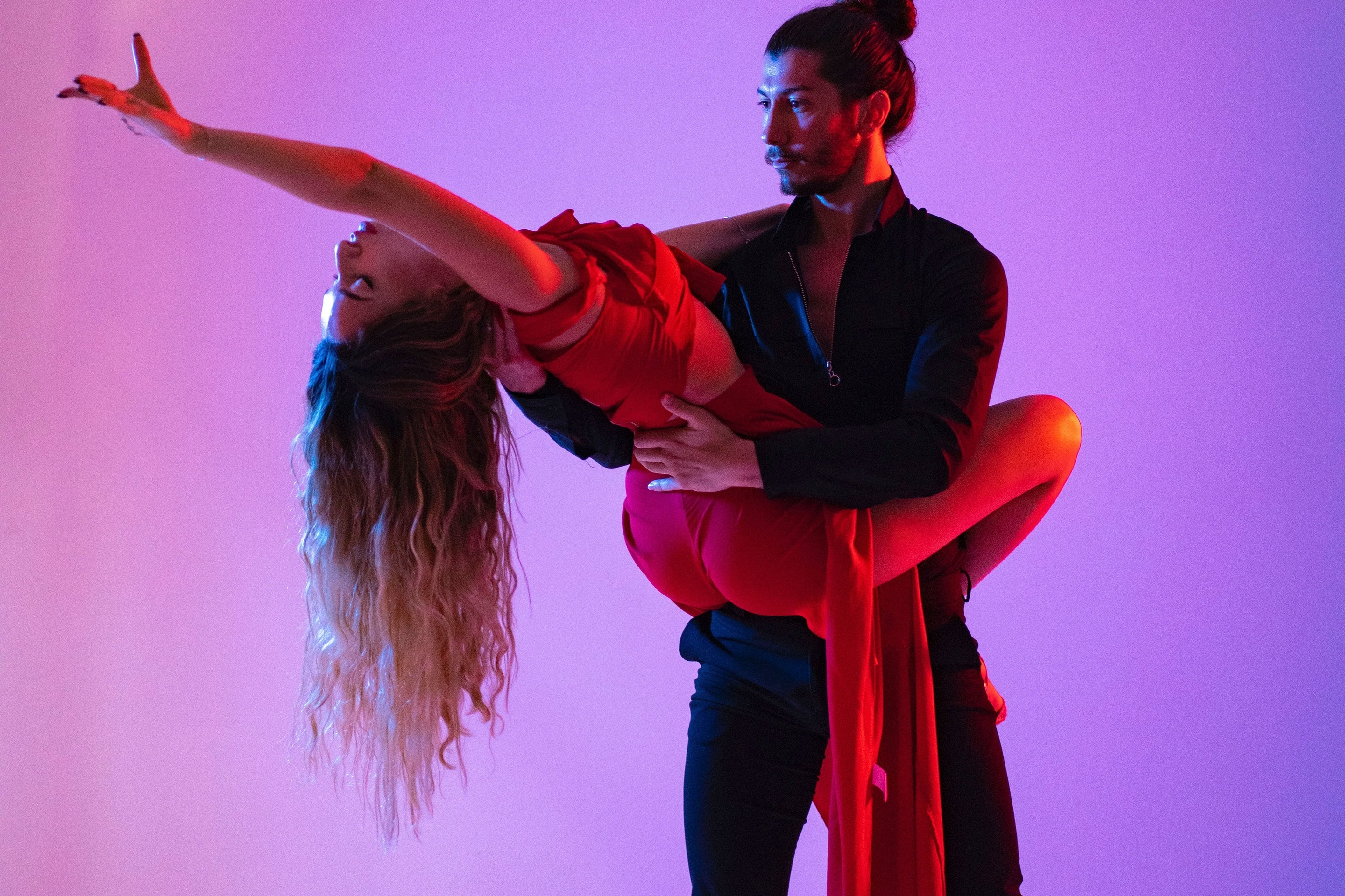 un hombre sostiene a una mujer en sus brazos mientras bailan