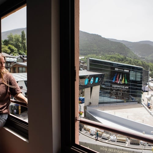 una mujer se sienta en un balcón mirando por la ventana