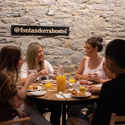 un grupo de personas se sienta alrededor de una mesa comiendo