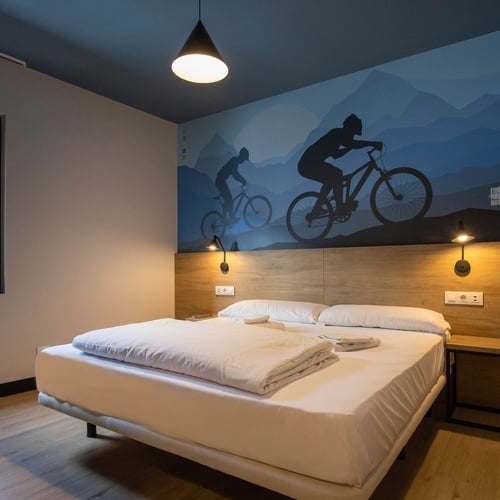 una habitación con una cama y una pintura de un hombre en una bicicleta