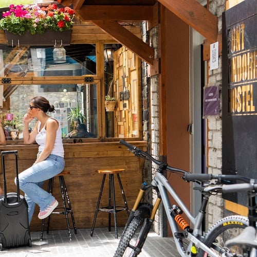 dos mujeres y una bicicleta frente a una puerta que dice hostel