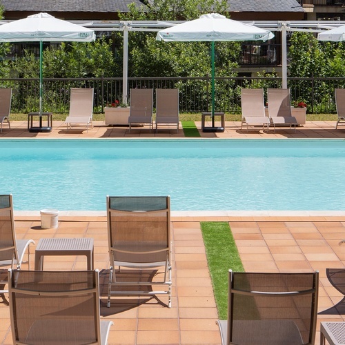 a swimming pool with chairs and umbrellas around it