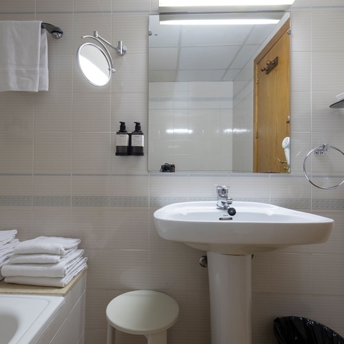 a bathroom with a sink a mirror and a hair dryer