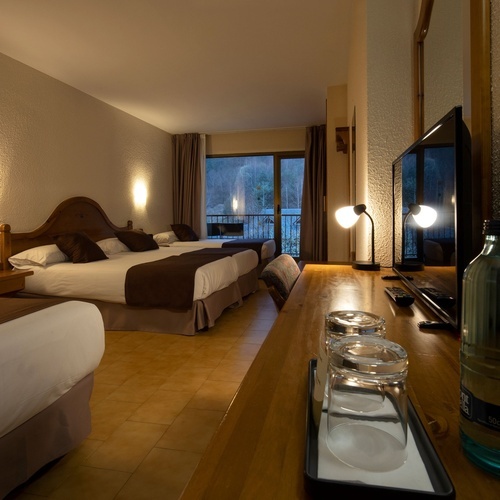 a bottle of water sits on a wooden desk in a hotel room