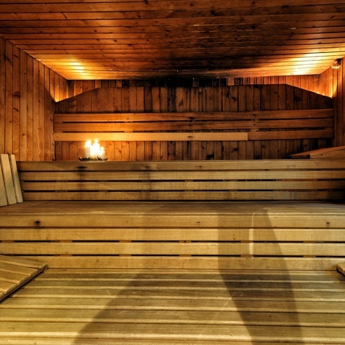 una sauna de fusta amb una vela al fons