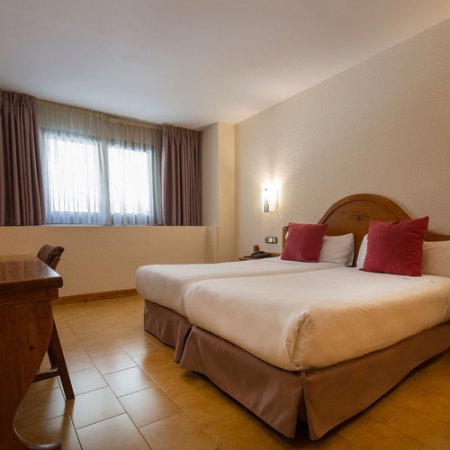 a hotel room with two beds and a desk