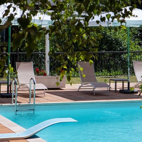 a swimming pool with chairs and an umbrella that says heineken