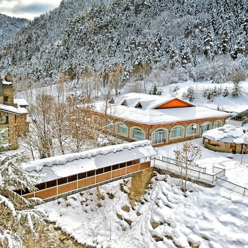 a snowy landscape with a building in the foreground